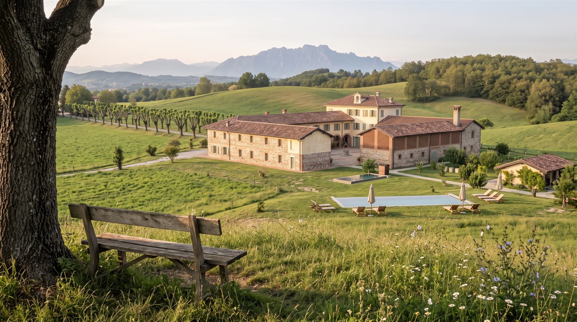 La piscina nel prato vista dal Belvedere, con la cascina e il Resegone sullo sfondo