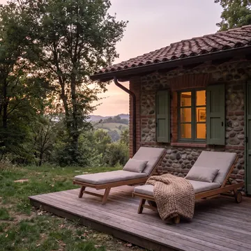 La terrazza in larice affacciata sul bosco al tramonto, con due sdraio