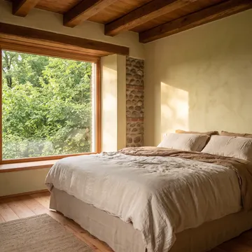 La camera con il letto in lino e la finestra piena di verde