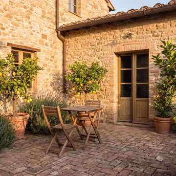 Il patio privato sulla corte, con un tavolino, i limoni in vaso e la lavanda